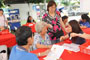 Student volunteer explaining to a resident on how to use the FIT kit.